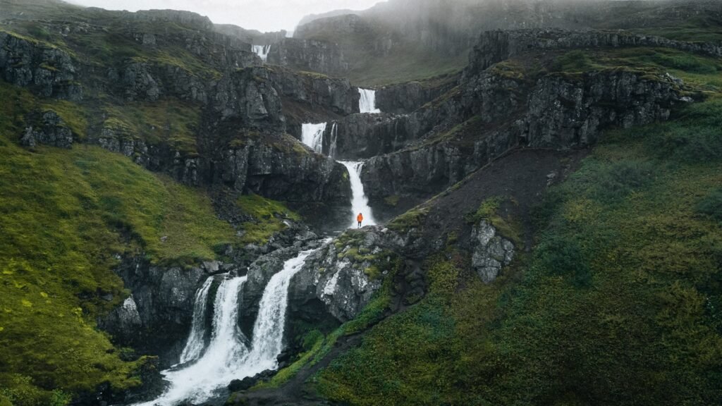 A waterfall in the middle of a lush green valley